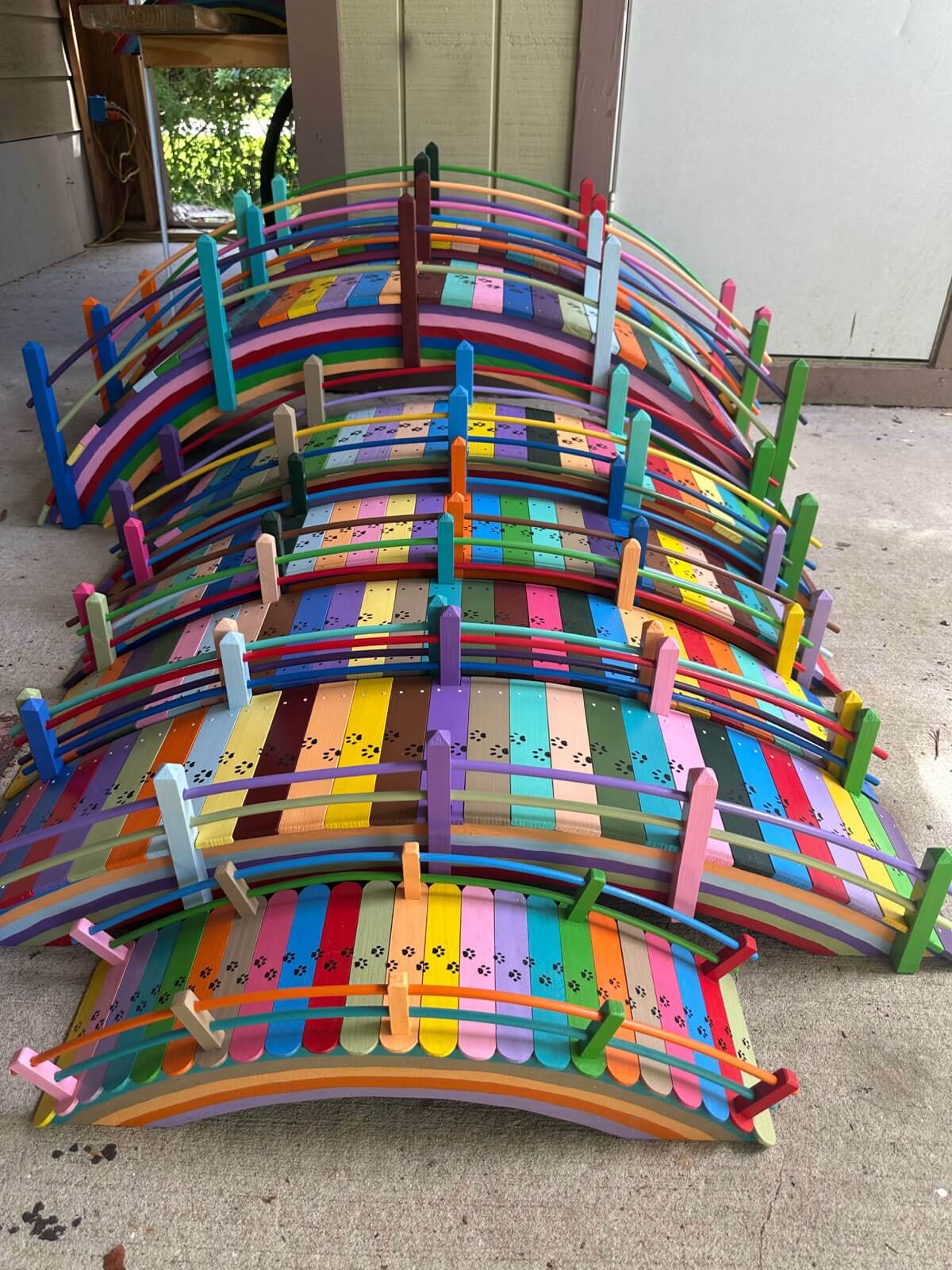 Paul's rainbow bridges lined up showing the arched design and colorful painted slats with paw prints
