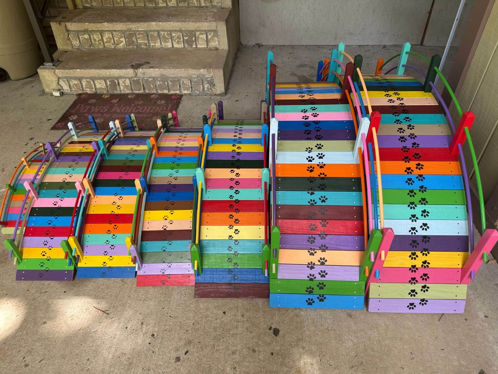 Dozens of Paul Allabaugh's handcrafted rainbow bridges, each one unique, painted in vivid colors with paw print details